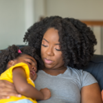 A mom cradles a young child