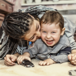 A mom kisses a laughing child