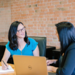 Two women talk in an office setting